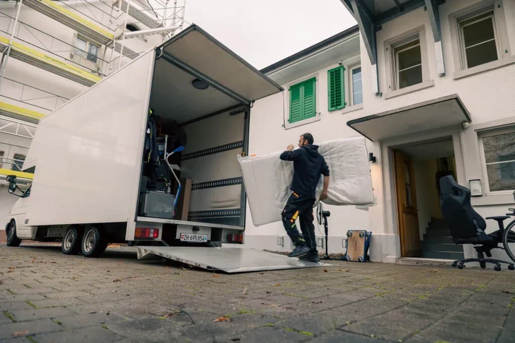 Büromobiliar wird über die Rampe des Umzugsfahrzeugs verladen