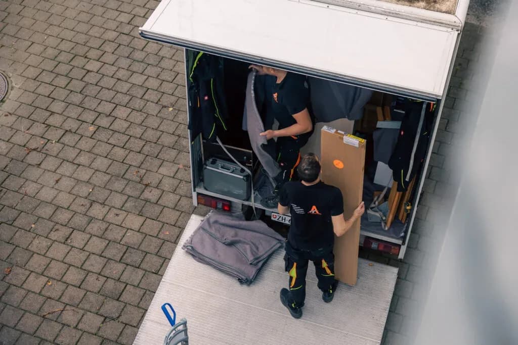 Zwei Mitarbeitende von Activ Umzüge verladen Umzugsgut in den Lastwagen